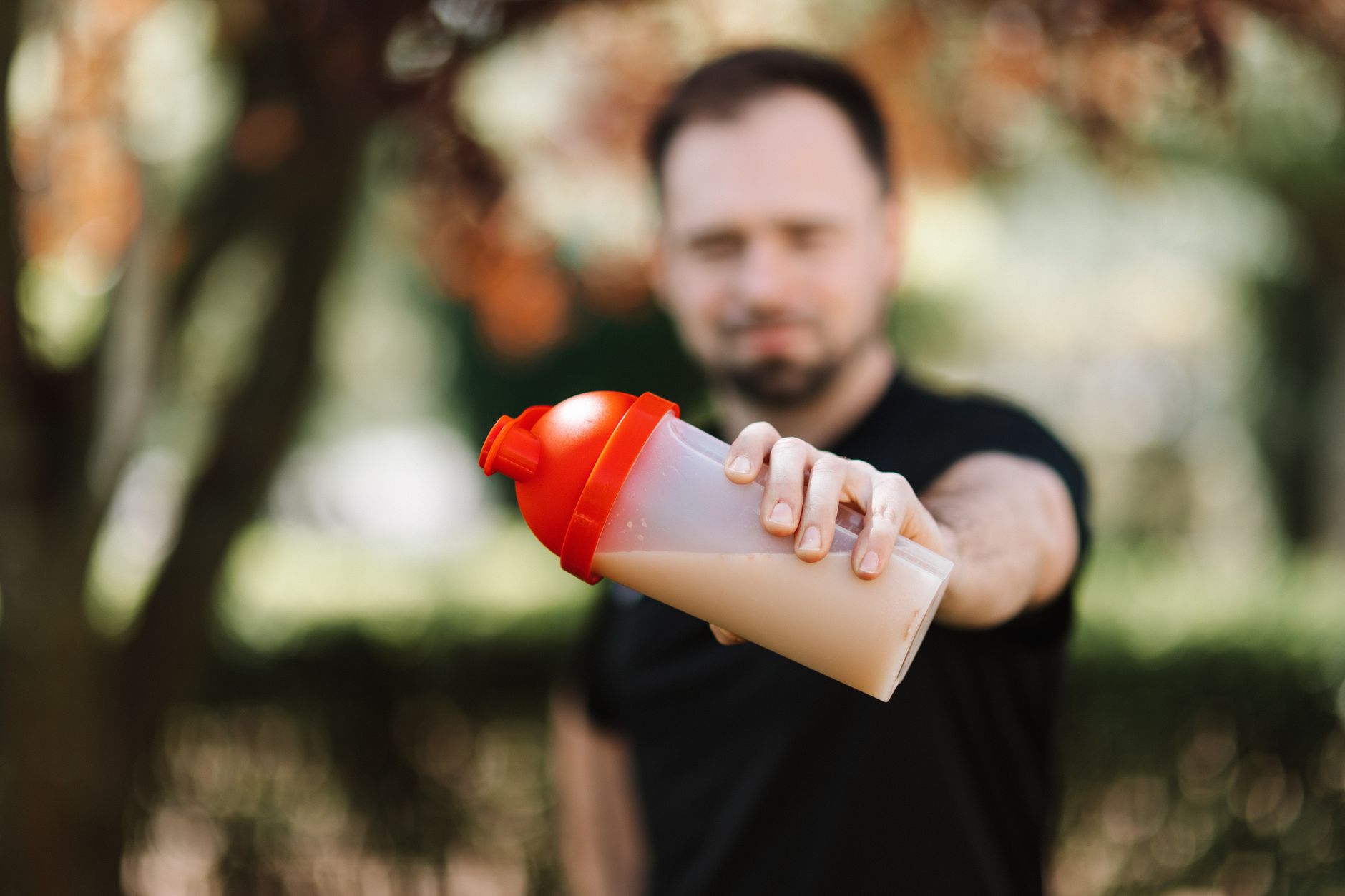Shaker de whey posé près d'haltères, ambiance salle de sport
